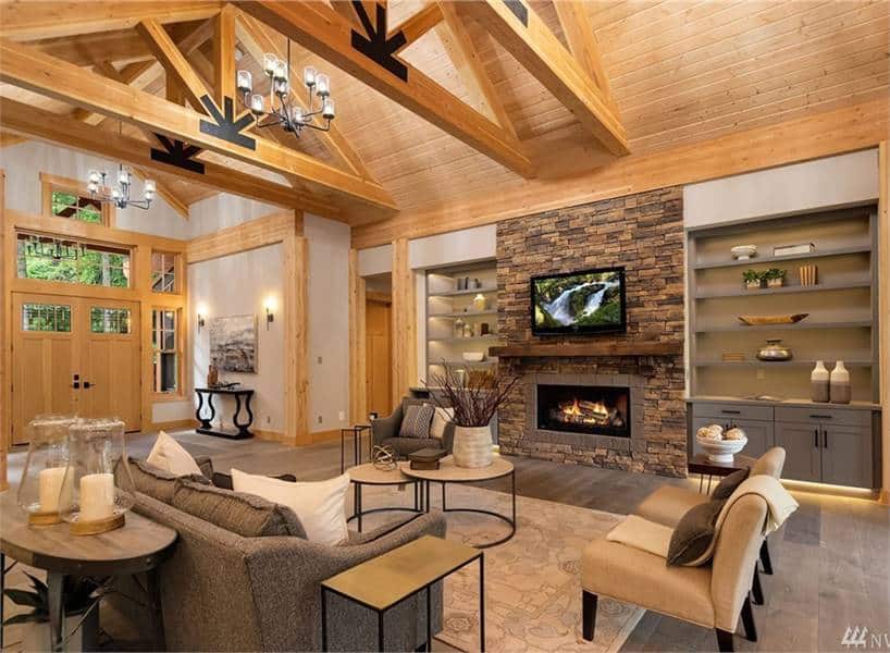 天然木材元素贯穿整个客厅，营造出温暖舒适的氛围，而石头壁炉则成为戏剧性的焦点。