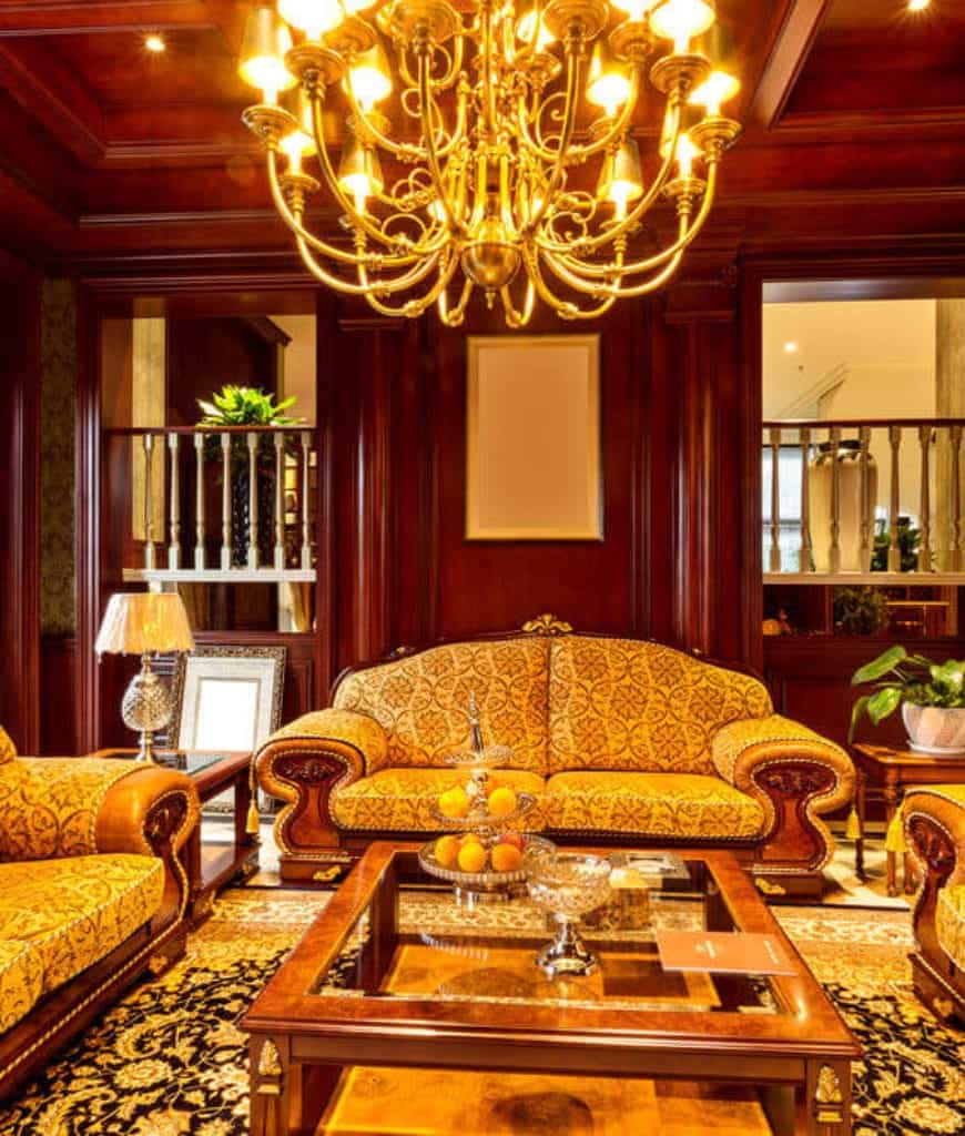 温暖的客厅，黄铜枝形吊灯挂在玻璃咖啡桌上，周围是优雅的花纹沙发。