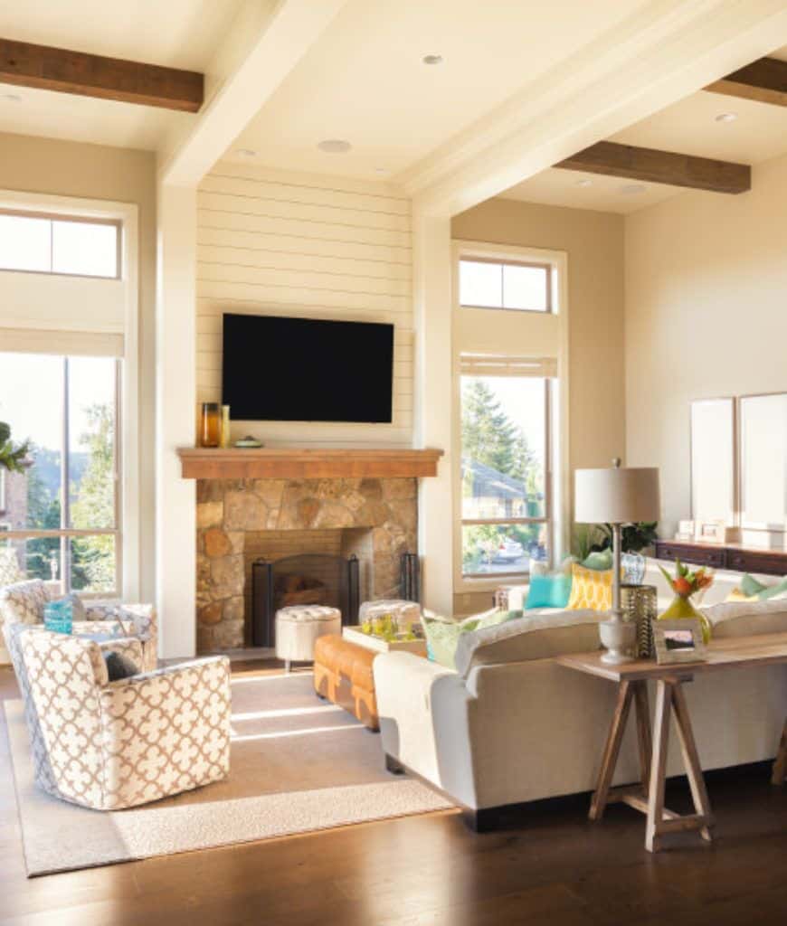 一个通风的客厅展示了平板电视安装在上面的墙搭叠口音的石壁炉内衬木制壁炉架。