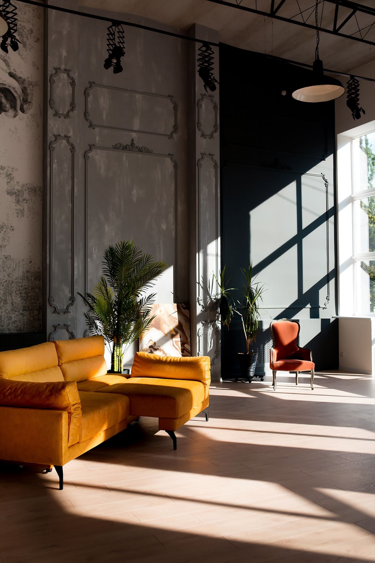 现代客厅阁楼有一个热带风格的审美与光明设计家具和盆栽棕榈植物在空间高天花板和硬木地板。