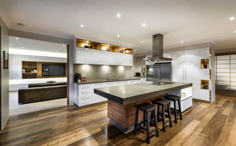 这是一个亚洲风格的厨房，结合了一些现代元素，比如带有嵌入式灯的纯白色天花板、不锈钢用具以及通风罩。它们与厨房岛台和白色半岛台的灰色台面相匹配。