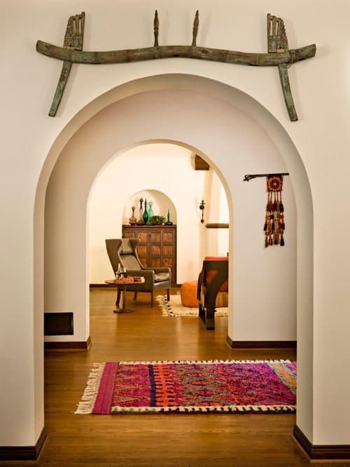 地中海式门厅充满了开放的拱门，上面有有趣的墙壁艺术，还有一个可爱的流苏地毯，铺在硬木地板上。
