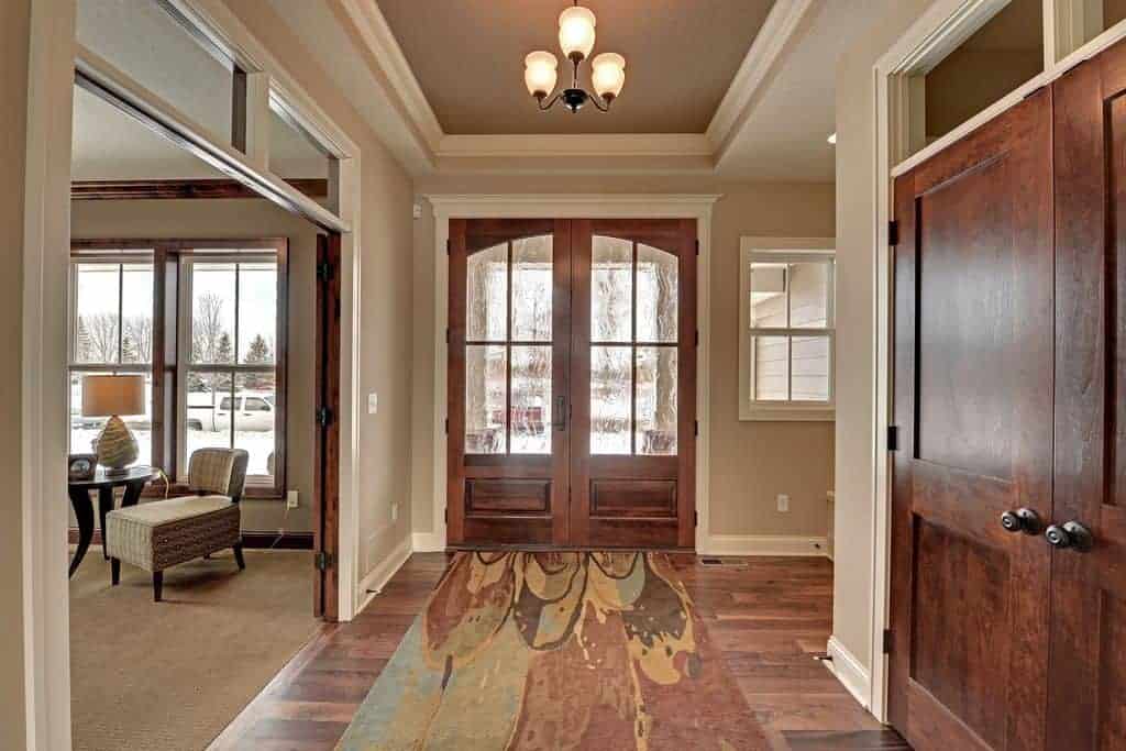 这个门厅以时尚的地毯为特色，通往家庭的生活空间。门厅里还有硬木地板和米黄色墙壁。
