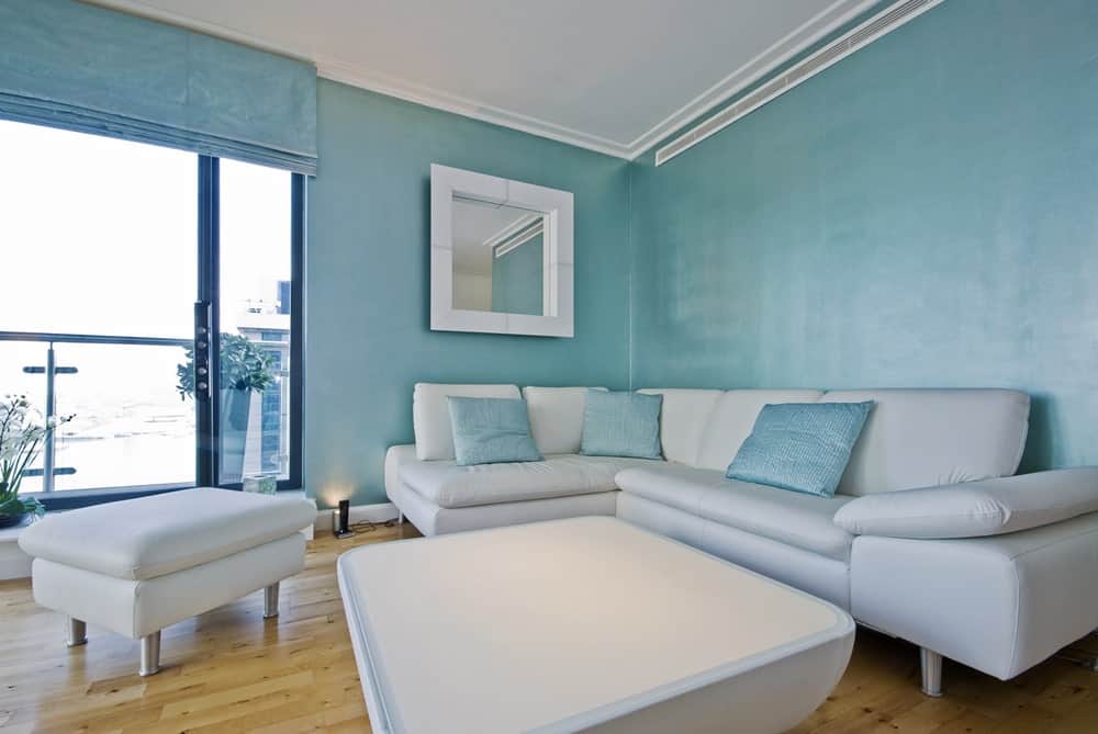 蓝色的客厅，硬木地板上有白色沙发。