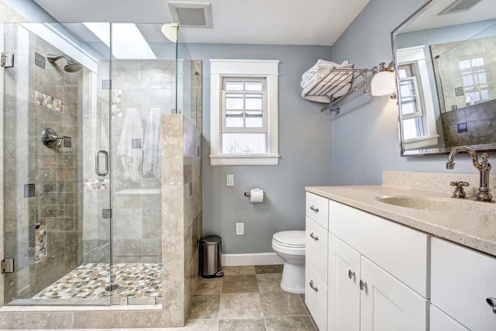 主浴室设有步入式淋浴间和带大理石台面的水槽。房间四周是蓝色的墙。