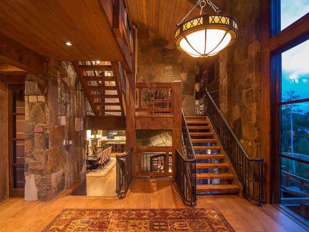门厅里有棕色的乡村风格的石墙和硬木地板，还有高高的木质天花板。