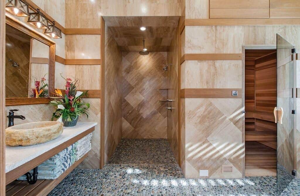 这间主浴室设有棕色瓷砖墙，设有开放式淋浴间和水槽。