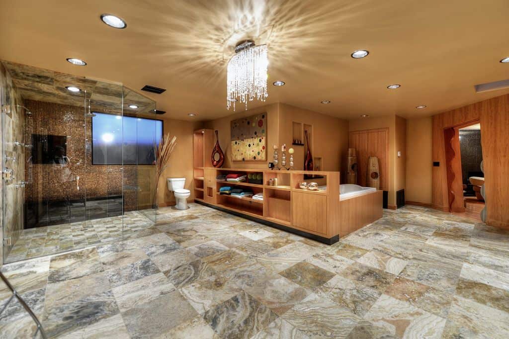 大型主浴室设有浴缸和步入式淋浴房，周围环绕着棕色墙壁和时尚的瓷砖地板。
