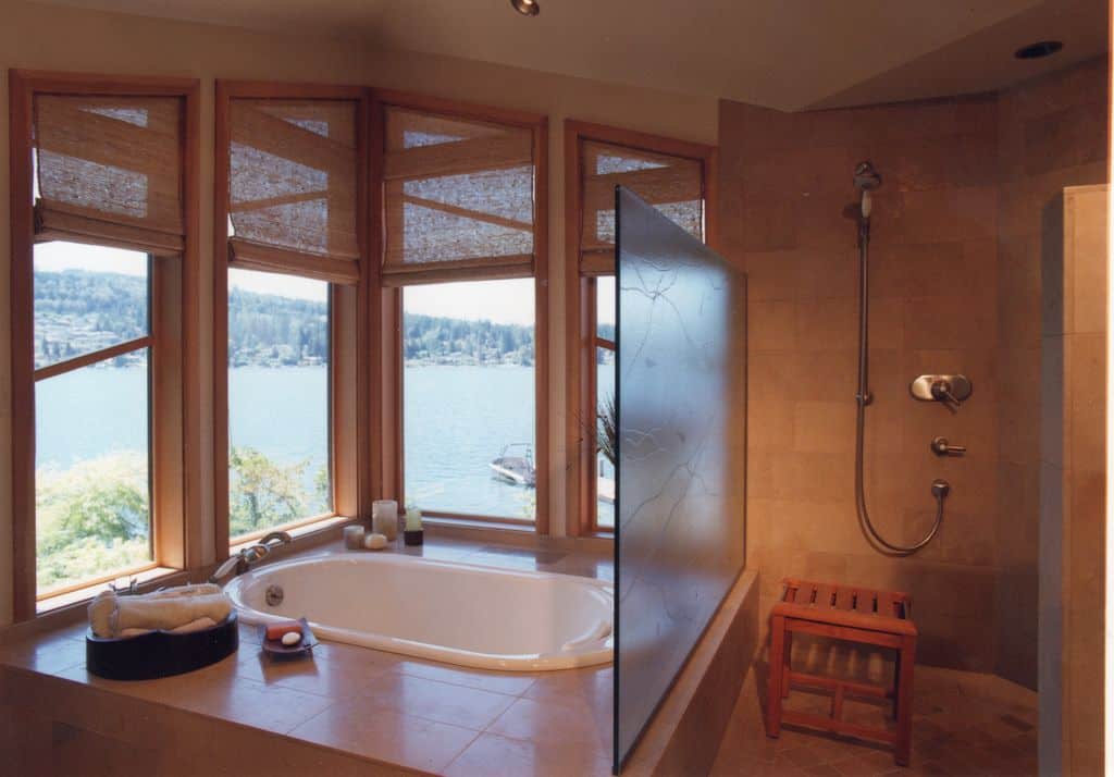 一间棕色的厨房，带一个可随意放置的浴缸和一间步入式淋浴间。浴缸位于玻璃窗附近，俯瞰着美丽的环境。