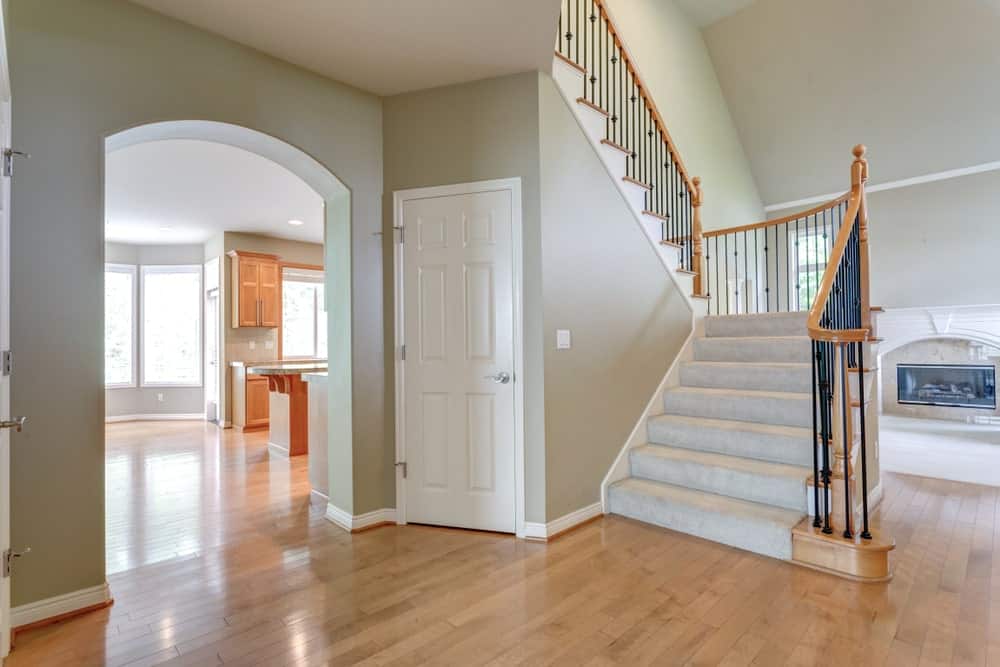 这间门厅设有硬木地板和带有灰色地毯台阶的楼梯。