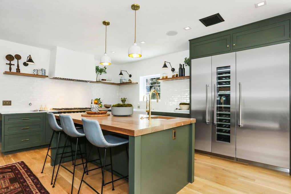 这间厨房设有绿色厨房柜台和带木质台面的绿色中心岛早餐吧。