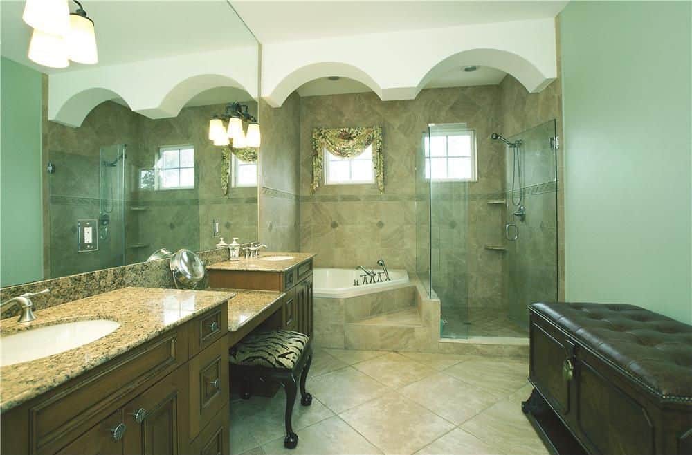 绿色主浴室设有两个水槽，一个粉末区，一个角落浴缸和一个步入式淋浴房。