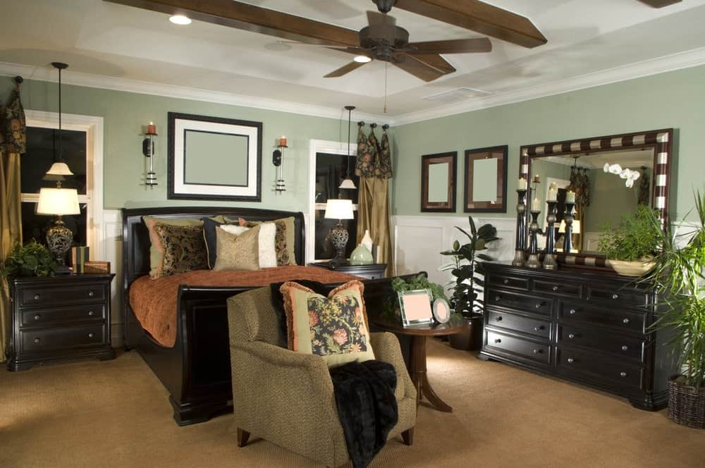 这间主卧室的特色是绿色的墙壁和地毯地板，以及经过浓缩咖啡处理的家具。