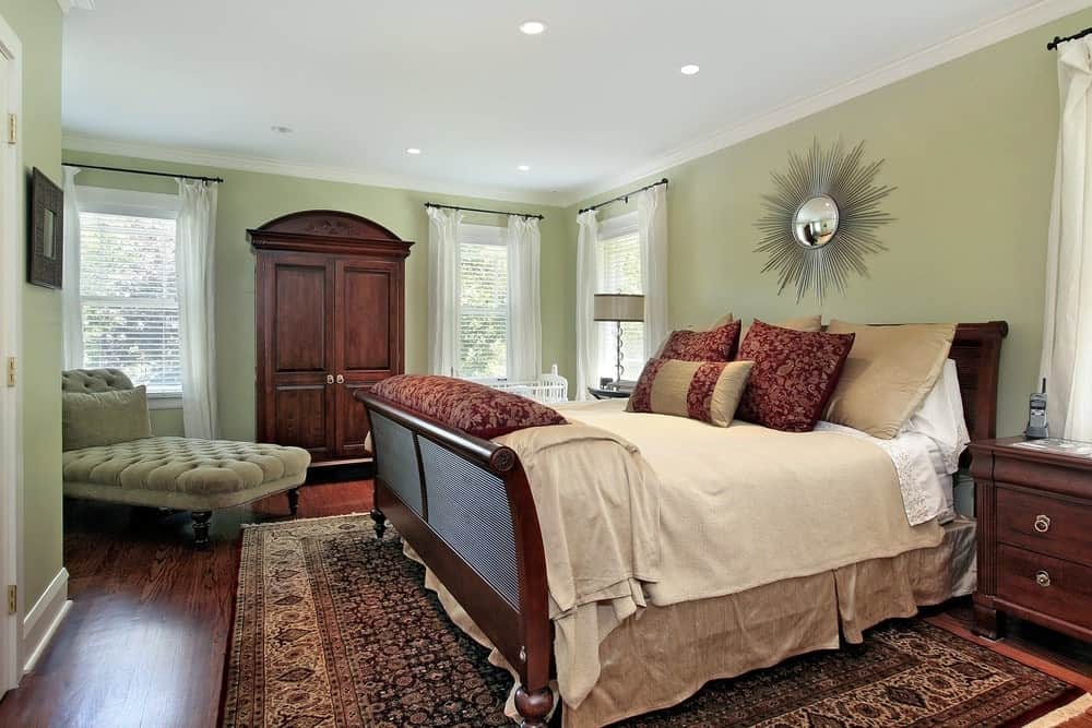 主卧室里铺着厚实的硬木地板，上面铺着大面积的地毯，四周环绕着绿色的墙壁。