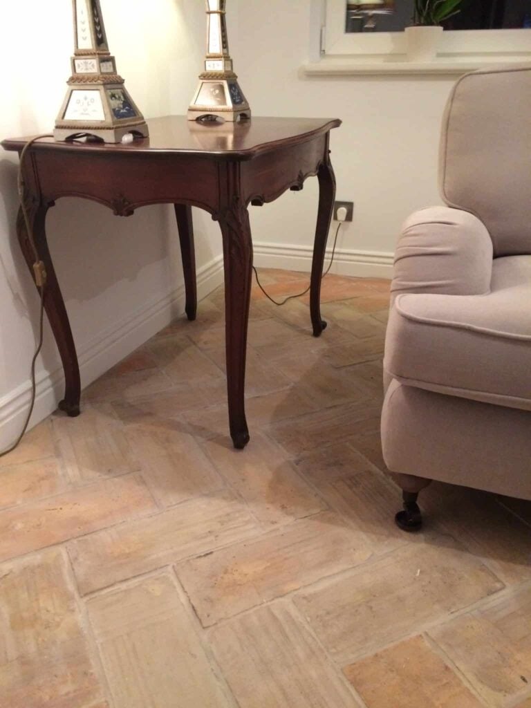 浅色的赤陶瓷砖地板，上面放着一把椅子和一张桌子。