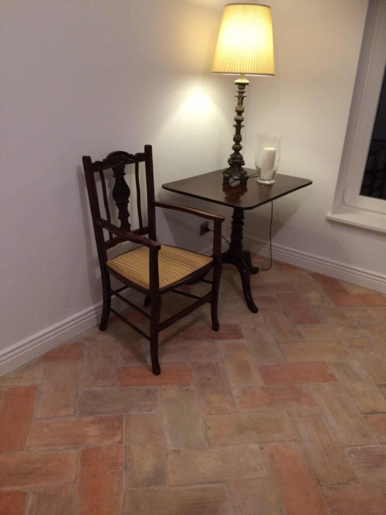 Terracotta瓷砖地板上家里的客厅被白墙包围。