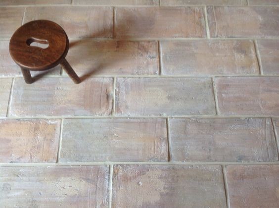 苍白的赤陶砖铺着地板，上面放着一张小凳子。