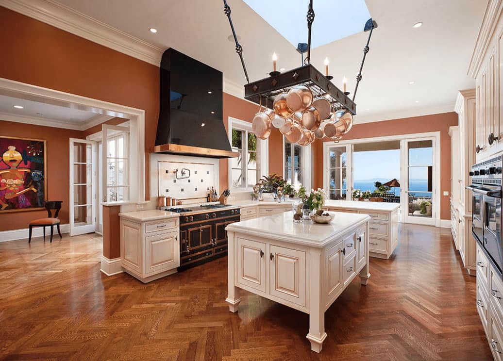 华丽的厨房，白色橱柜与黑色油烟机形成对比，可爱的锅架镶有钻石，挂在天窗下和厨房岛台上方。