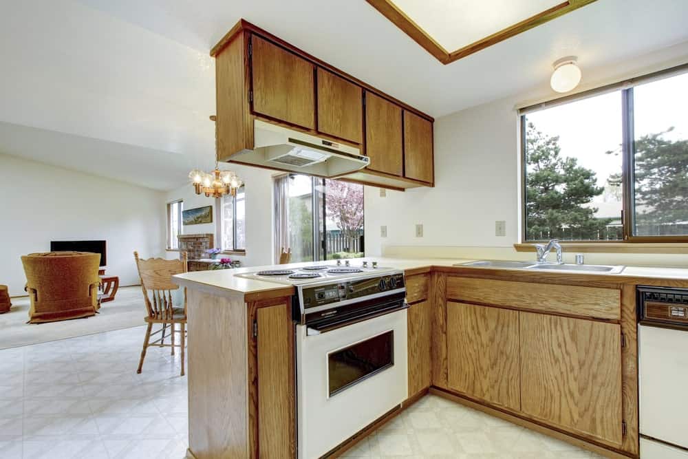 l型厨房展示了白色电器，与天然木质橱柜完美融合。