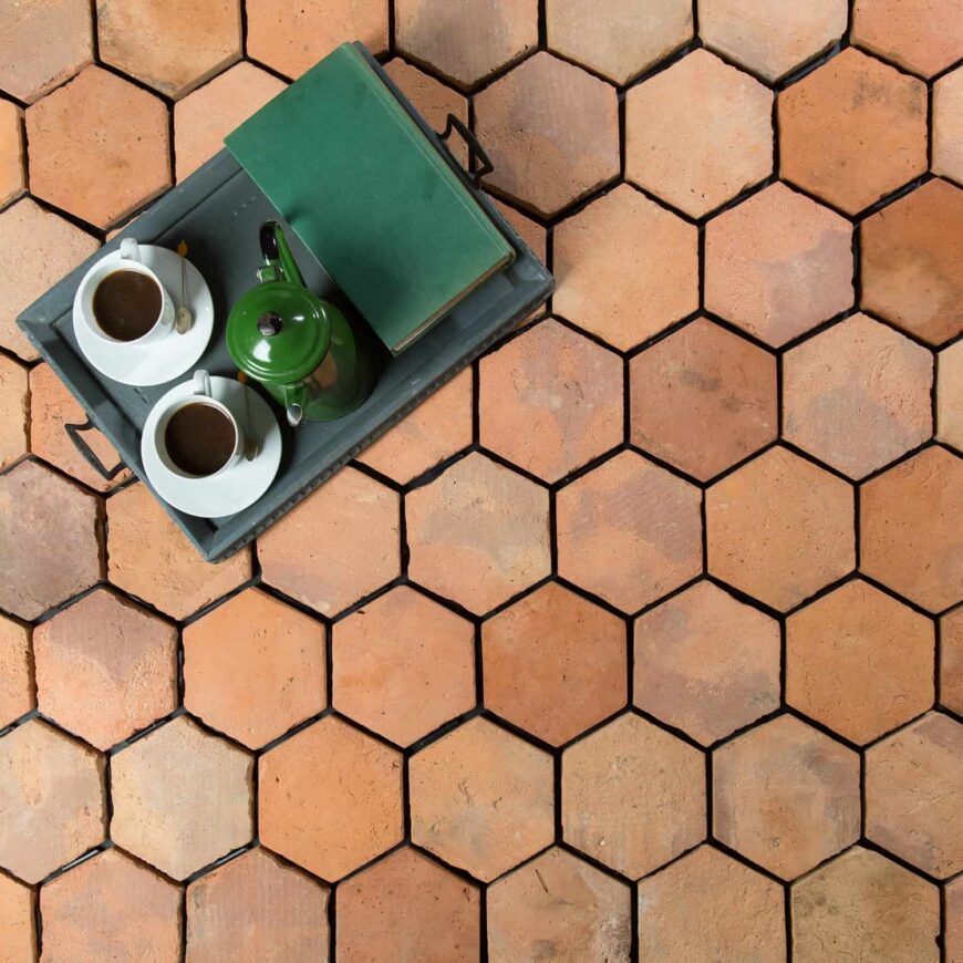 干净漂亮的六角terracotta瓷砖地板上一盘一套咖啡和一本书。