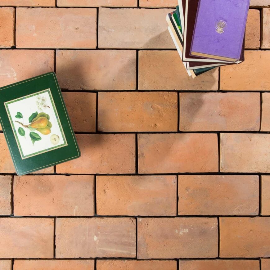 堆栈的书籍在terracotta砖瓷砖地板。