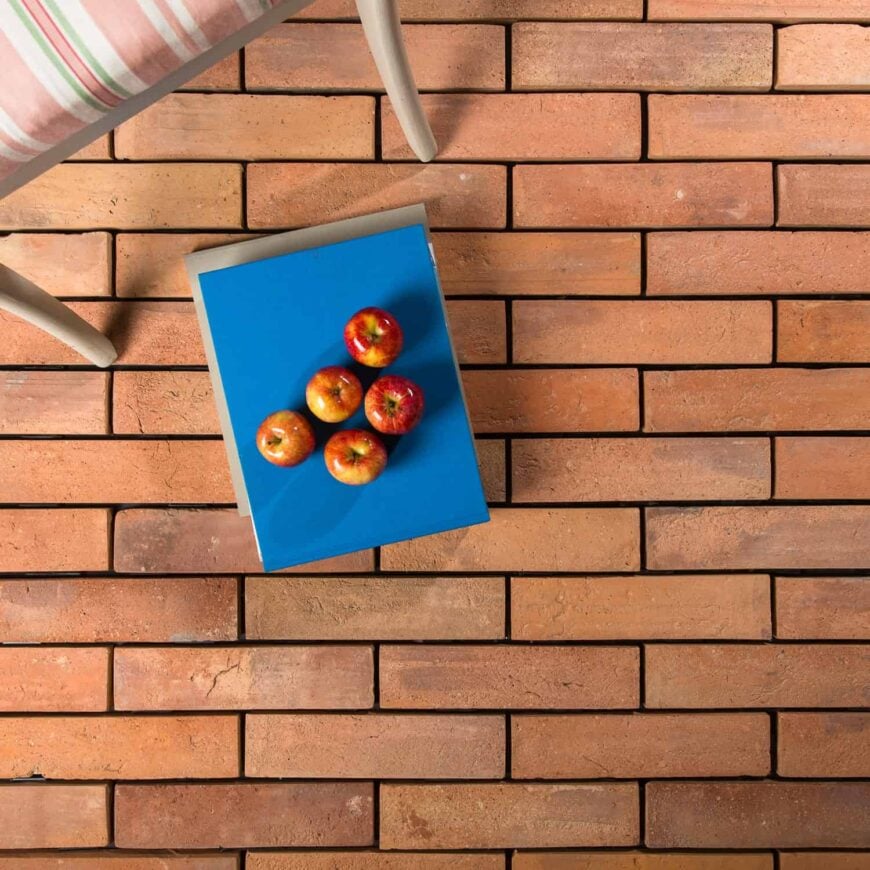 Terracotta砖瓷砖地板与苹果在上面。