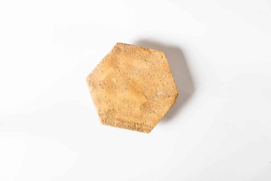 一个单一的六角形温暖的陶土瓷砖在白色的背景。