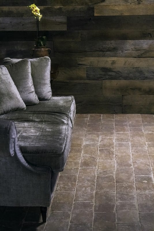 苍白的terracotta瓷砖地板有一个灰色的沙发上。