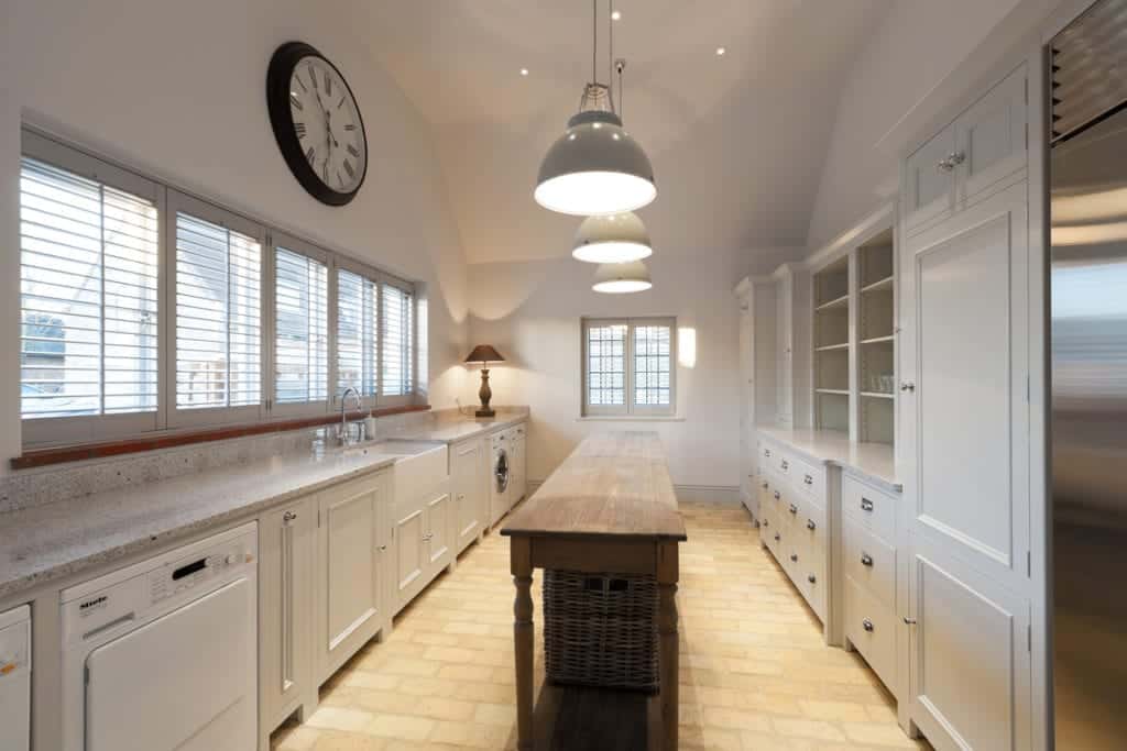 这间狭窄的厨房设有一个长长的岛台，位于陶瓦砖地板上。