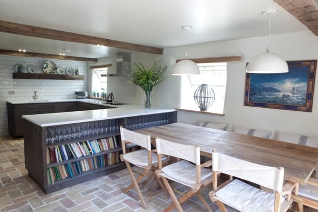 宽敞的餐厅厨房设有一个漂亮的柜台和餐桌设置在赤陶砖瓷砖地板。