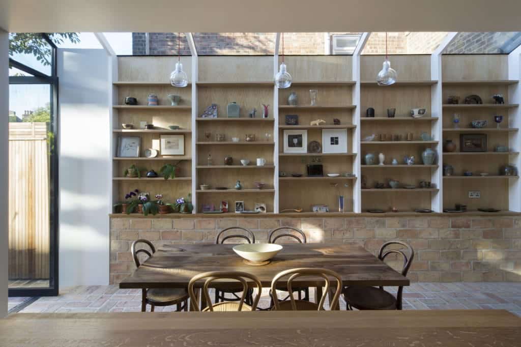 一间餐厅厨房，内有巨大的内置架子，铺着赤陶土瓷砖的地板和墙壁。