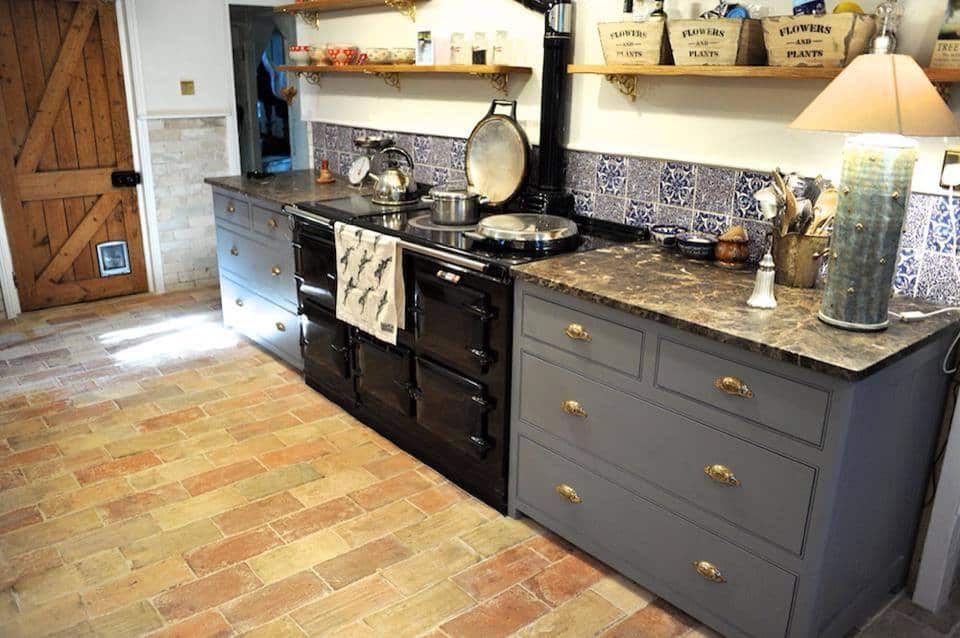 小厨房区与时尚的厨房柜台和砖陶土瓷砖地板。