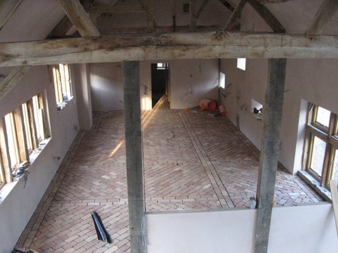 一个空房间,白色的墙壁和terracotta砖瓷砖地板。