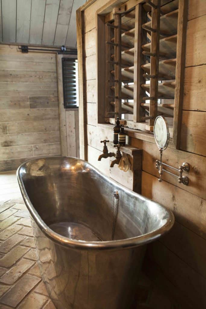 近距离观察这间主浴室的独立浴缸，浴缸放置在房间的赤陶土瓷砖地板上。