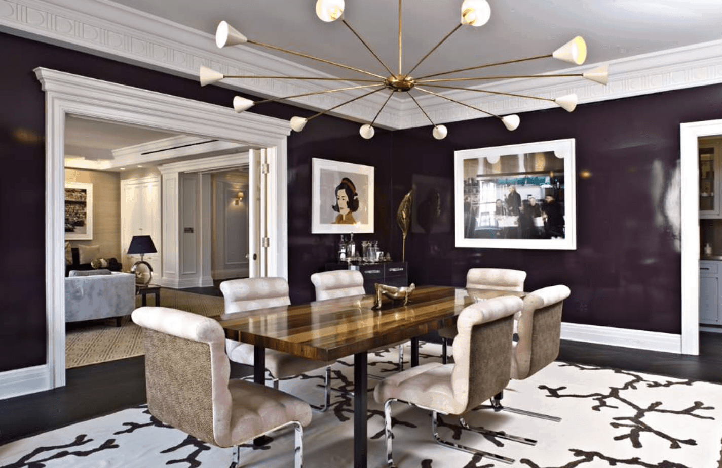 宽敞的餐厅设有一个大的时尚地毯覆盖深色地板。餐桌和椅子看起来绝对时尚，由一个惊人的天花板照明。房间四周环绕着紫色的墙壁，墙壁上装饰着迷人的装饰品。