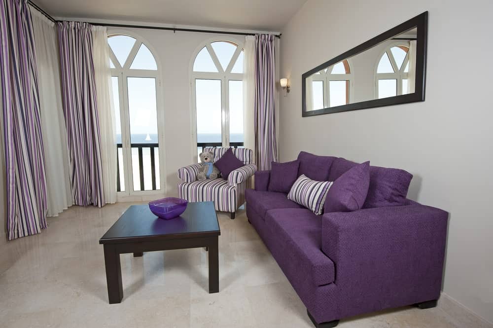 小的生活空间，有一个紫色的沙发。房间的地板与墙壁和天花板搭配起来很完美。
