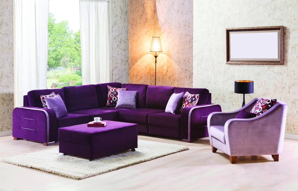正式的客厅拥有一个优雅的沙发套与配套的软脚凳套在白色地毯上。