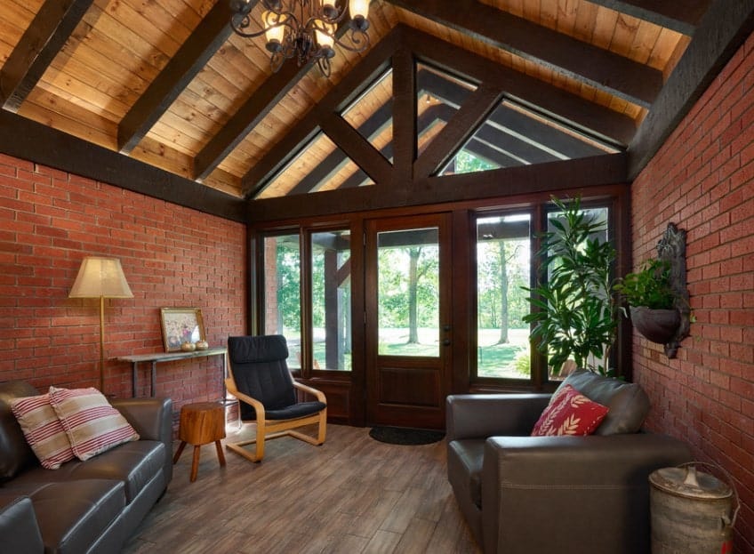 宽敞的门厅设有红砖墙和硬木地板。它还提供一张沙发和两把椅子。