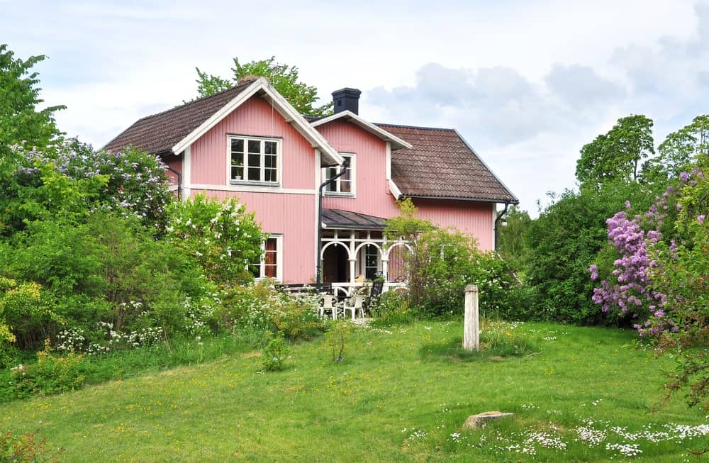 充满春天元素的景观与房屋外立面的粉红色非常适合。它有各种开花植物和灌木，在房子入口的两侧，以及中型树木，构成了迷人的区域。