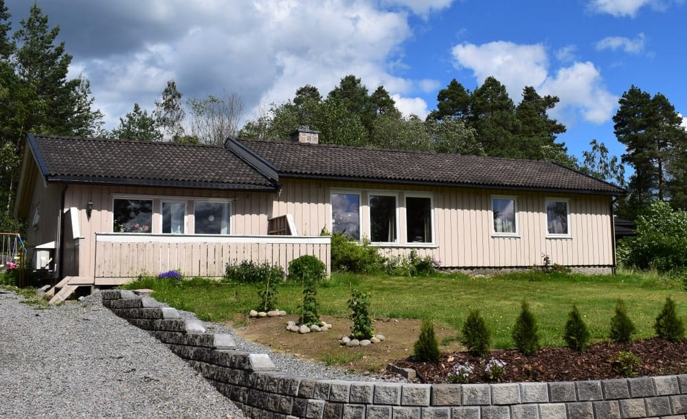 斯堪的纳维亚风格的家与自然景观和石砖硬景观。