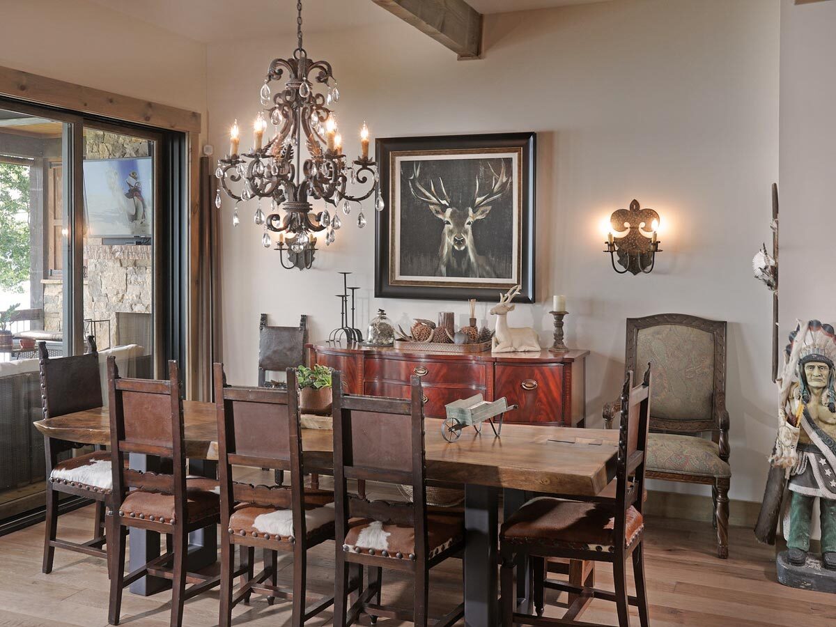 工匠餐厅的木制家具，一个华丽的锻铁枝形吊灯，米黄色的墙壁装饰着鹿艺术品和温暖的烛台。