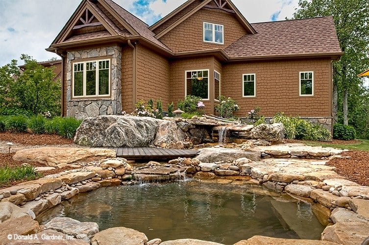 雪松小屋的石头风格反映了令人惊叹的人造池塘，池塘以瀑布和木板甲板为特色。