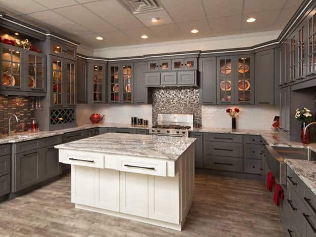 在这个可爱的u型厨房里，你会看到震动柜的设计与所有灰色的橱柜和抽屉一致，白色的厨房岛台与半岛台的台面相同。