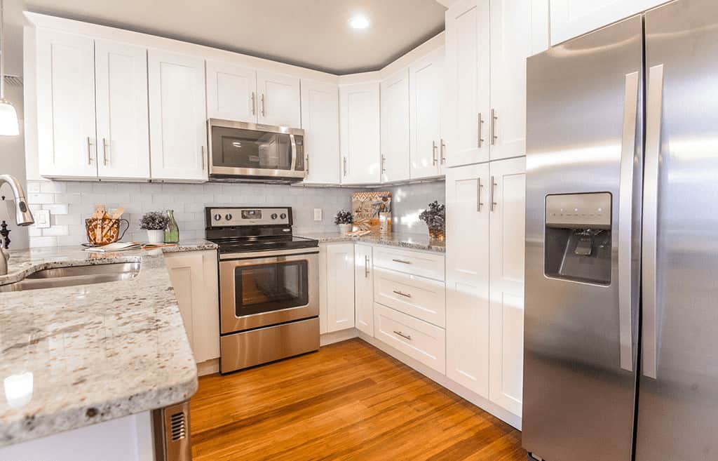 悬挂木结构的白色摇床柜遵循厨房墙壁的布局，并与厨房半岛连接，以提供充足的硬木地板空间。