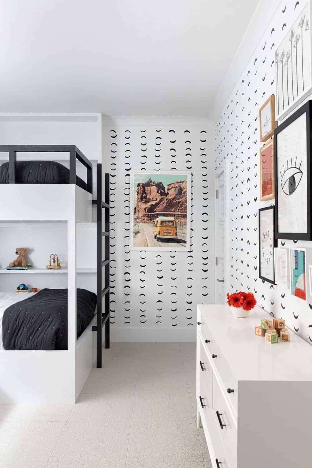 这个孩子的卧室设有时尚的黑白双层床和吸引人的墙壁设计。