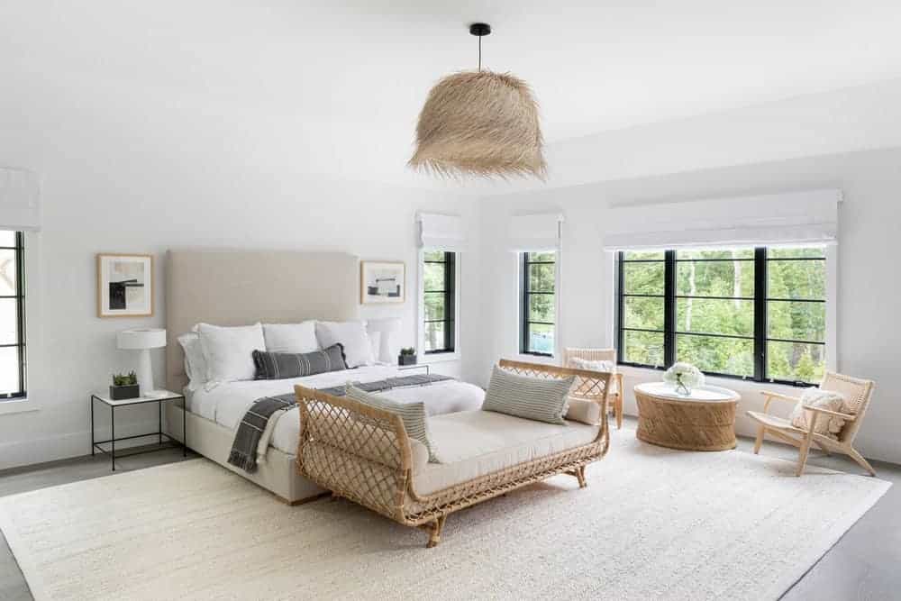 宽敞的卧室设有硬木地板，白色墙壁和天花板，以及大棕色地毯。