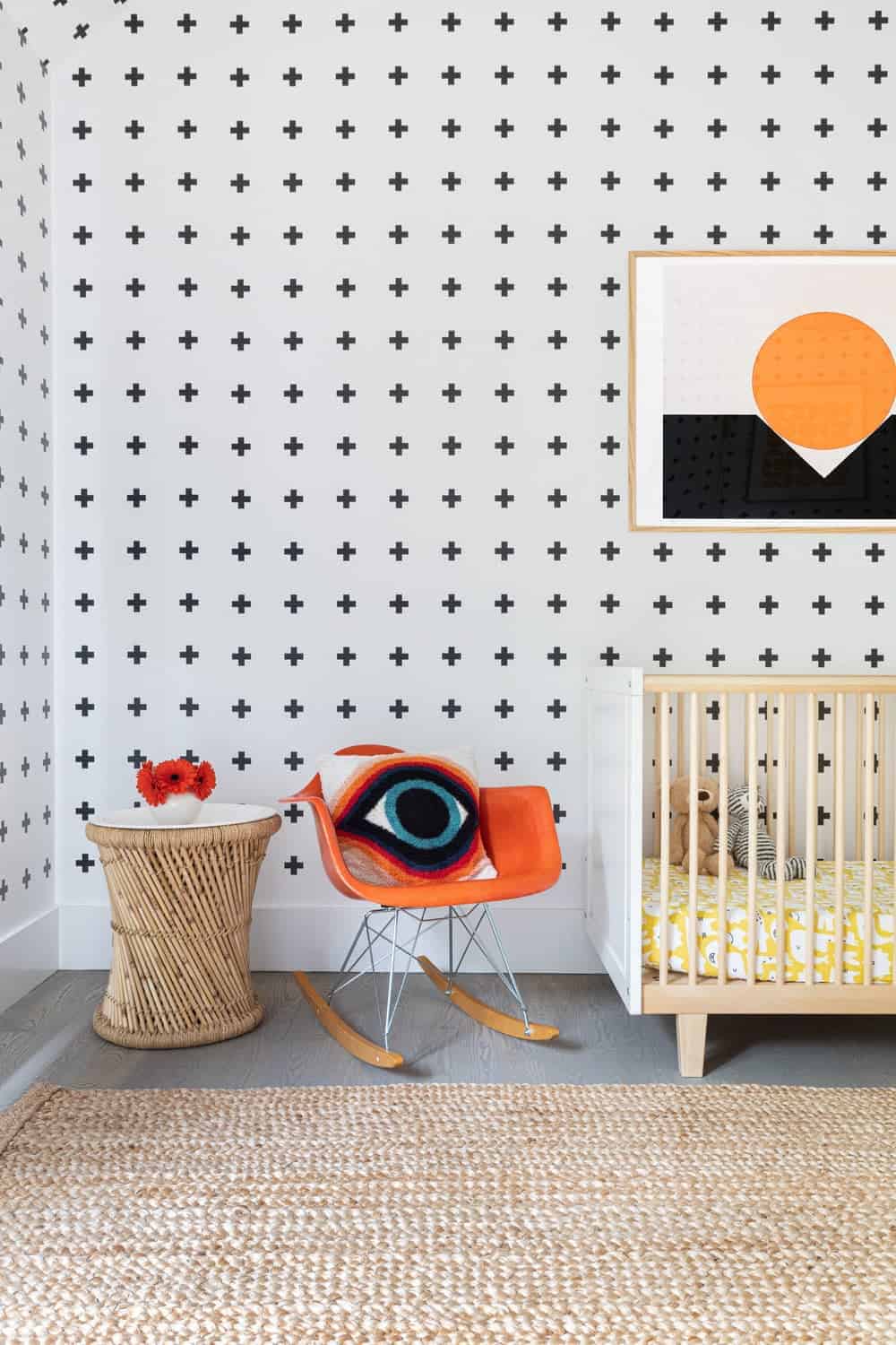 这间育婴室以时尚的墙壁设计和大面积地毯覆盖的灰色硬木地板为特色。