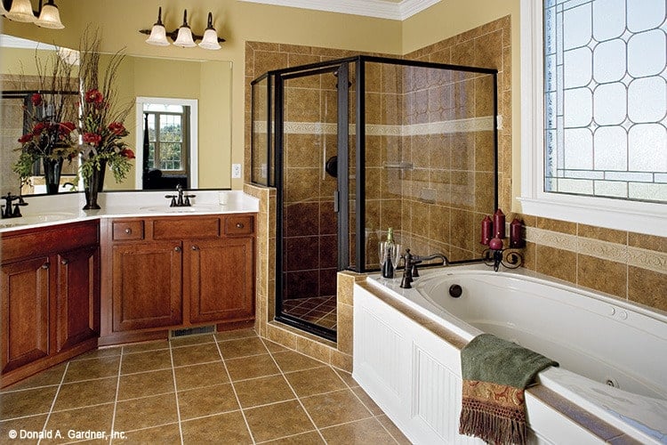 瓷砖地板延伸到浴缸和淋浴后挡板，增强了这个传统主浴室的经典外观。