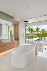 宽敞的现代海岸风格浴室让您感觉就像在五星级度假胜地度假一样。它的特色是一个光滑的独立浴缸，以及配套的带大镜子的浮动木梳妆台。