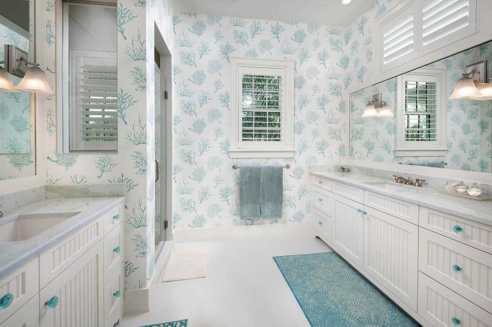 主浴室里有床头板梳妆台、一个玻璃围成的淋浴区，以及有图案的墙纸。